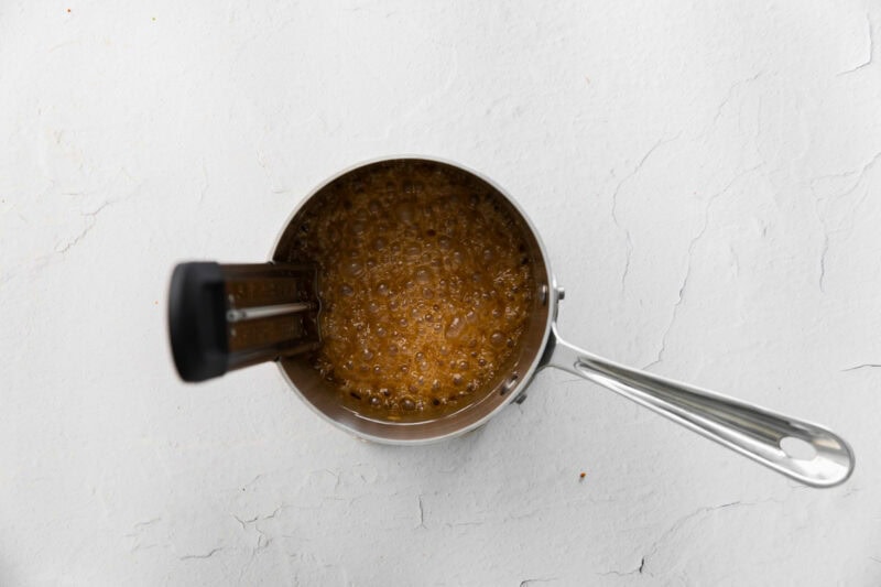 Checking the temperature of simmering caramel.