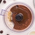 Chocolate Teddy graham cheesecake crust ingredients in a food processor.