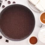 Chocolate cheesecake crust pressed into a springform pan.