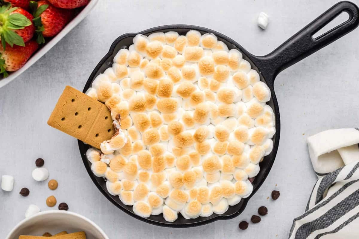 Cookie dipped into baked s'mores dip.
