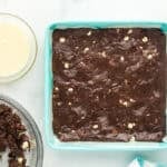 Chocolate brownie bar batter smoothed into a square baking pan.