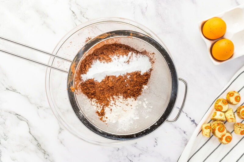Sifting dry ingredients into a mixing bowl.